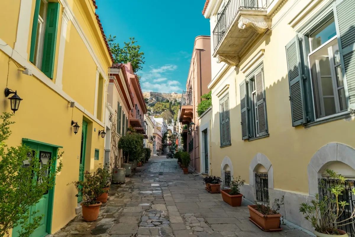A narrow street in Plaka with the sacred rock of the Acropolis rising in the background
